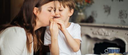 A child shares a snack with an adult