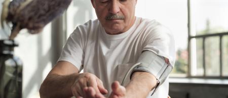 Middle-aged man with blood pressure monitor on his left arm