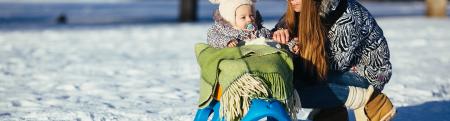 mother and baby daughter in winter clothing in the snow