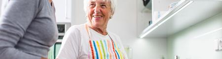 A woman helping her grandmother cook in the kitchen