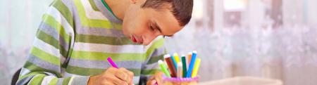 Boy at a desk writing in a book