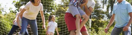 Multigenerational family playing soccer in a park together