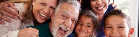Multigenerational Hispanic family taking a selfie with a birthday cake