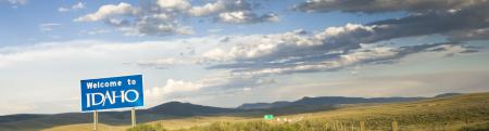 Photo of Welcome to Idaho sign standing along highway in desert