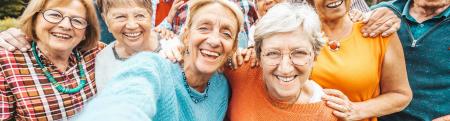 group of older individuals taking a selfie