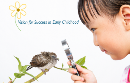 child looking at a bird through a magnifying glass.