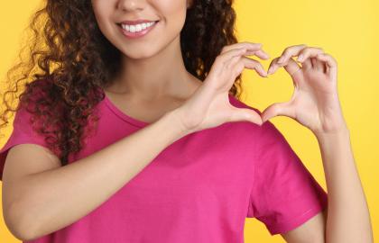 Young woman making a heart shape with her hands