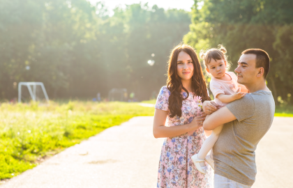 2-1-1 Happy young family standing in a park in summer