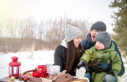 Happy family drinking cocoa outdoors on a snowy day