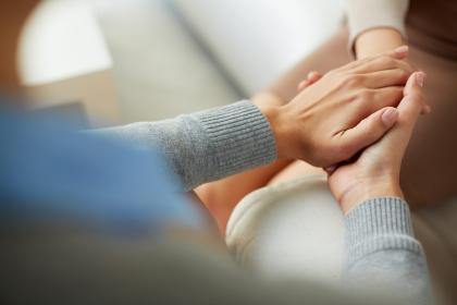 People holding hands in comfort