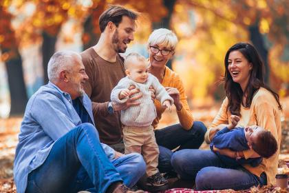 Family sitting in park in the fall