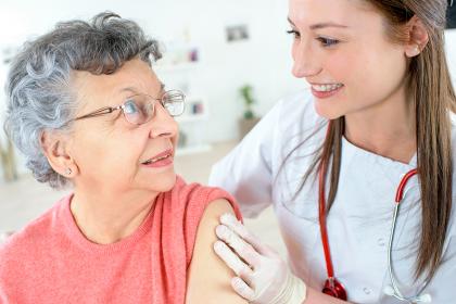 Nurse bandages woman after a vaccination