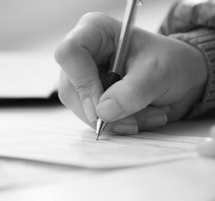 Close up of a person filling out a paper form