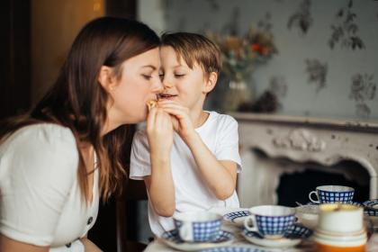 A child shares a snack with an adult
