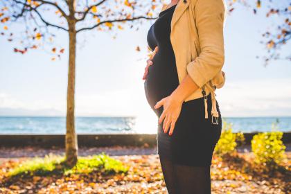 Pregnant woman outside near a lake