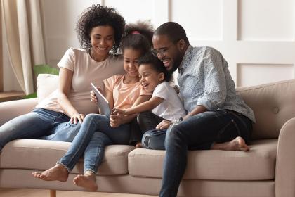 A family on an ipad sitting on a cough 