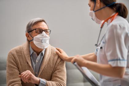 Older adult wearing a vented mask with a provider