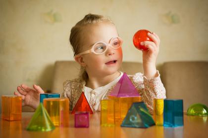 Young girl playing with colored shaped blocks