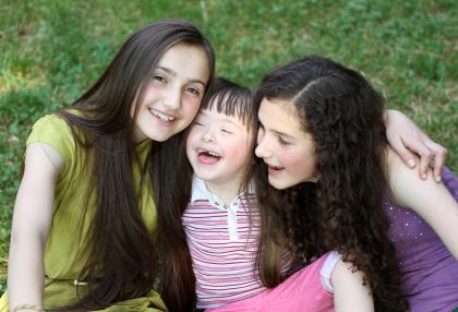 Two teen girls with little downs syndrome girl