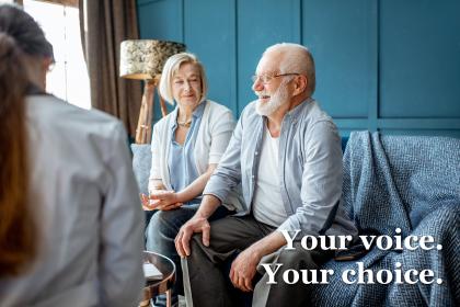 Older couple sitting with a doctor in a blue room
