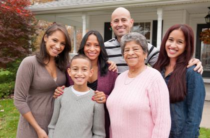 Hispanic family standing int he front of their house