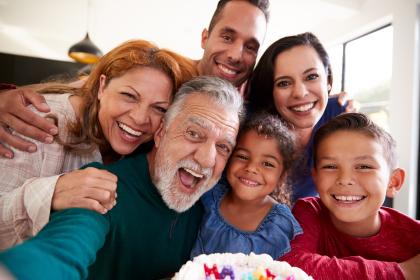 Multigenerational Hispanic family taking a selfie with a birthday cake