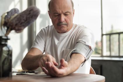 Middle-aged man with blood pressure monitor on his left arm