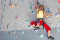 Young girl climbing indoor rock wall