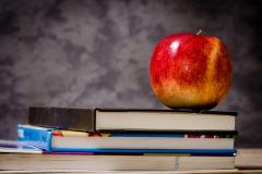 An apple sits atop a stack of books