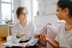 Two adults talking together on a couch